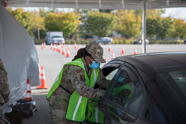 A member of the Delaware National guard administers a COVID-19 vaccine under a TentCraft drive-thru tent solution.