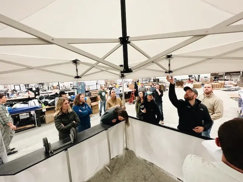 TentCraft employees inspect a new pop-up tent on the production floor