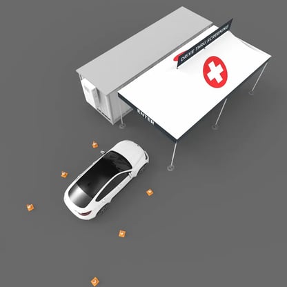 birds-eye-view of a car pulling into a drive thru medical tent that has a cross printed on the roof and a banner attached