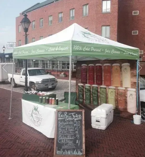 The medium-duty pop-up tent with custom back walls created for juice company at product demos.