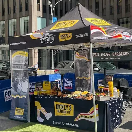 A 10x10 medium-duty pop-up tent with table cover for use in a commercial filmed in New York City.