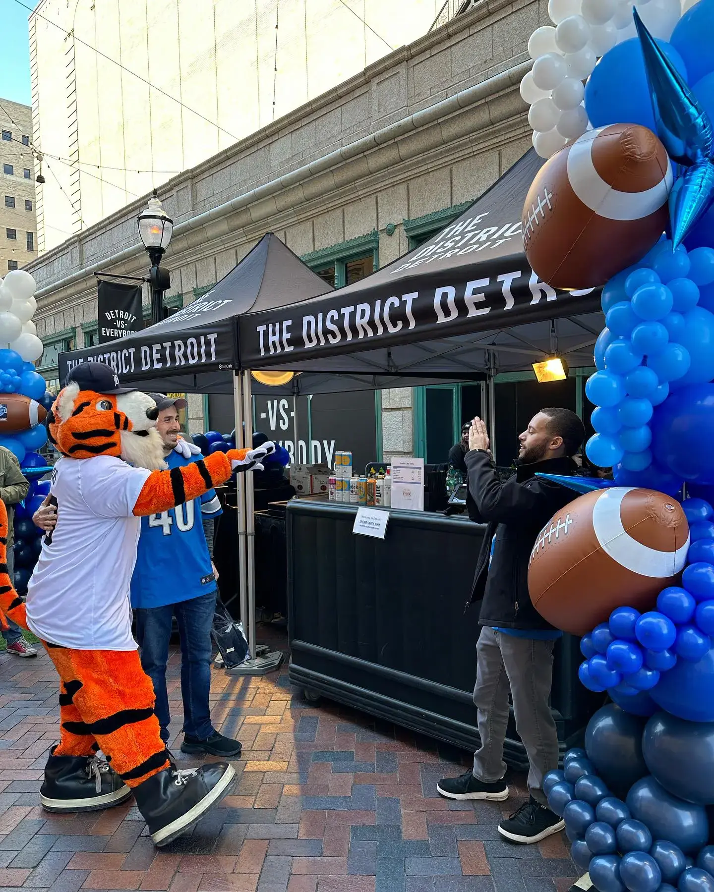 Detroit Tigers mascot Paws interacts with a fan during a District Detroit event