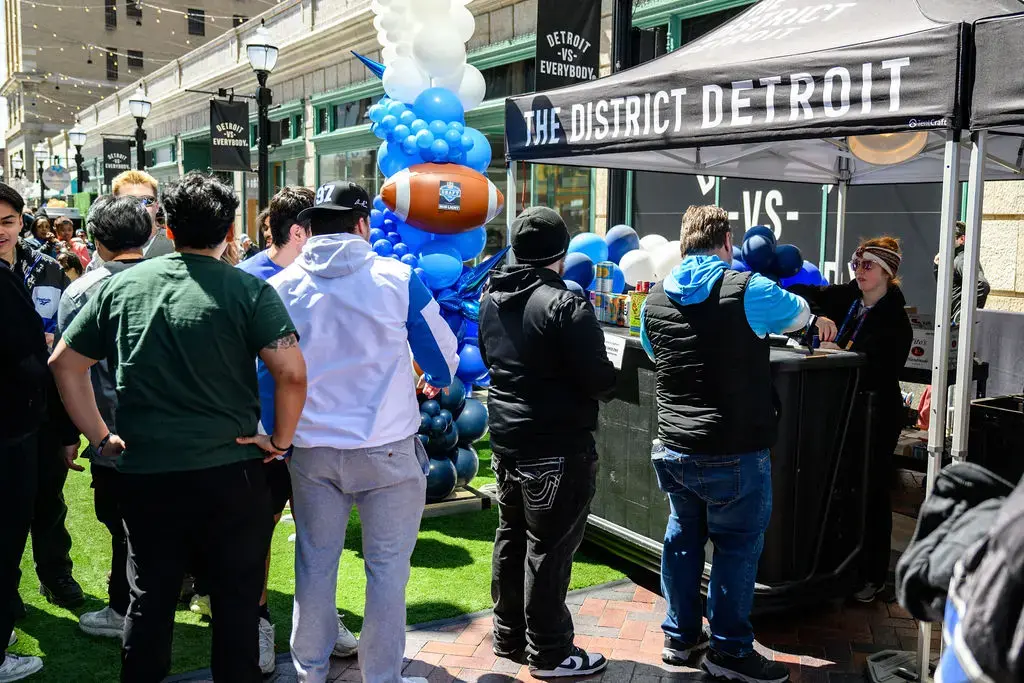 Lions tailgaters wait in line for a beverage at a District Detroit event