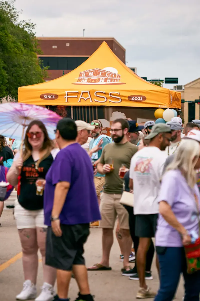 Crowds walk by a Fass Brewing pop-up tent at an event