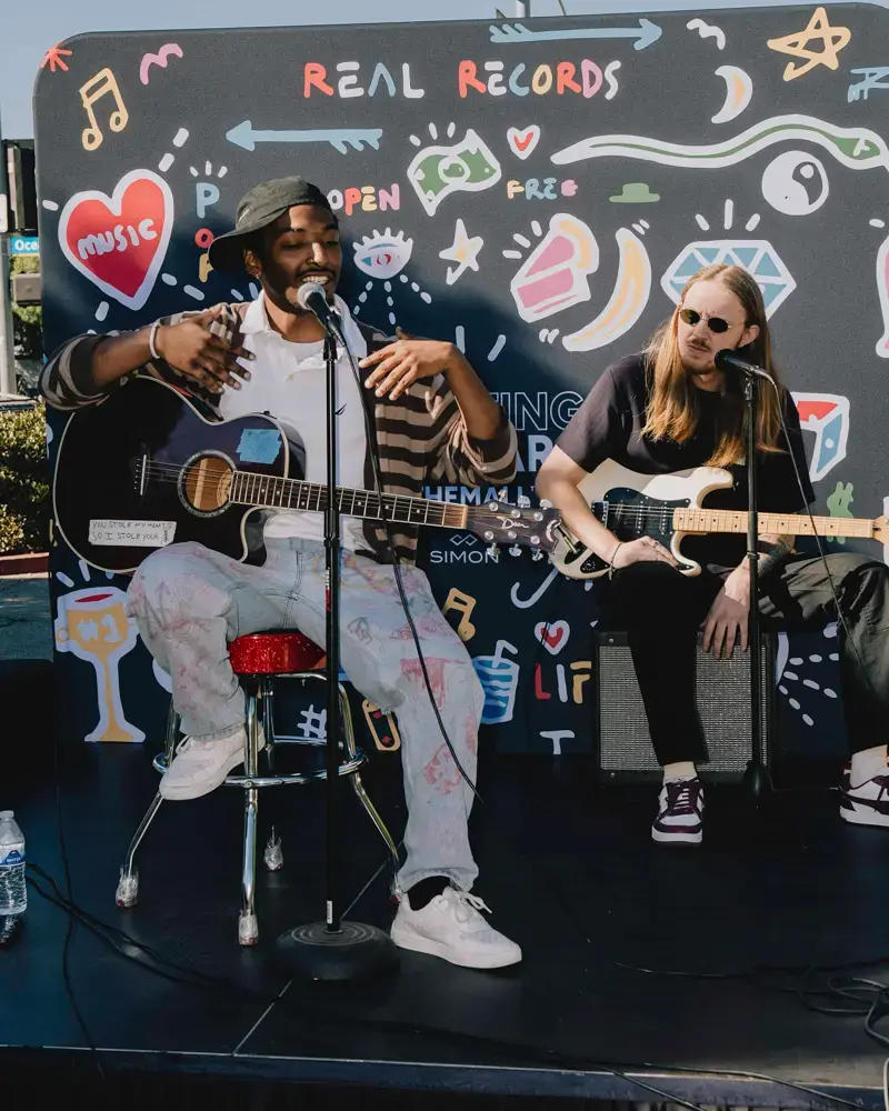 Performers in front of a Greater Than Distribution backdrop