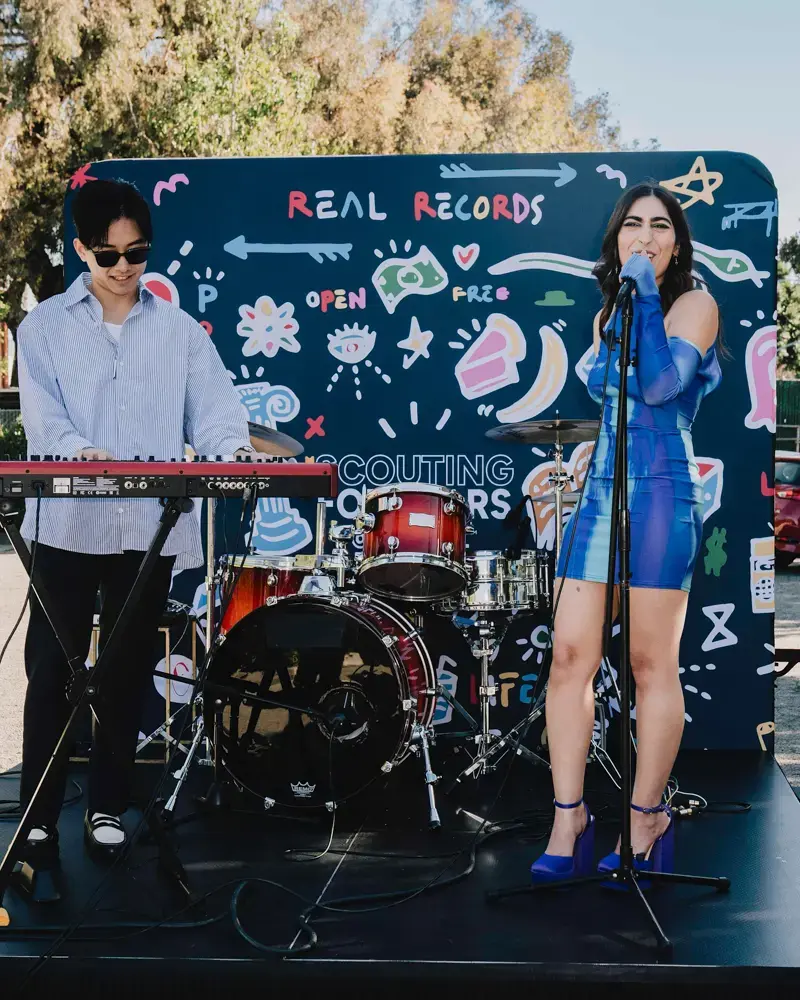 Performers in front of a Greater Than Distribution backdrop