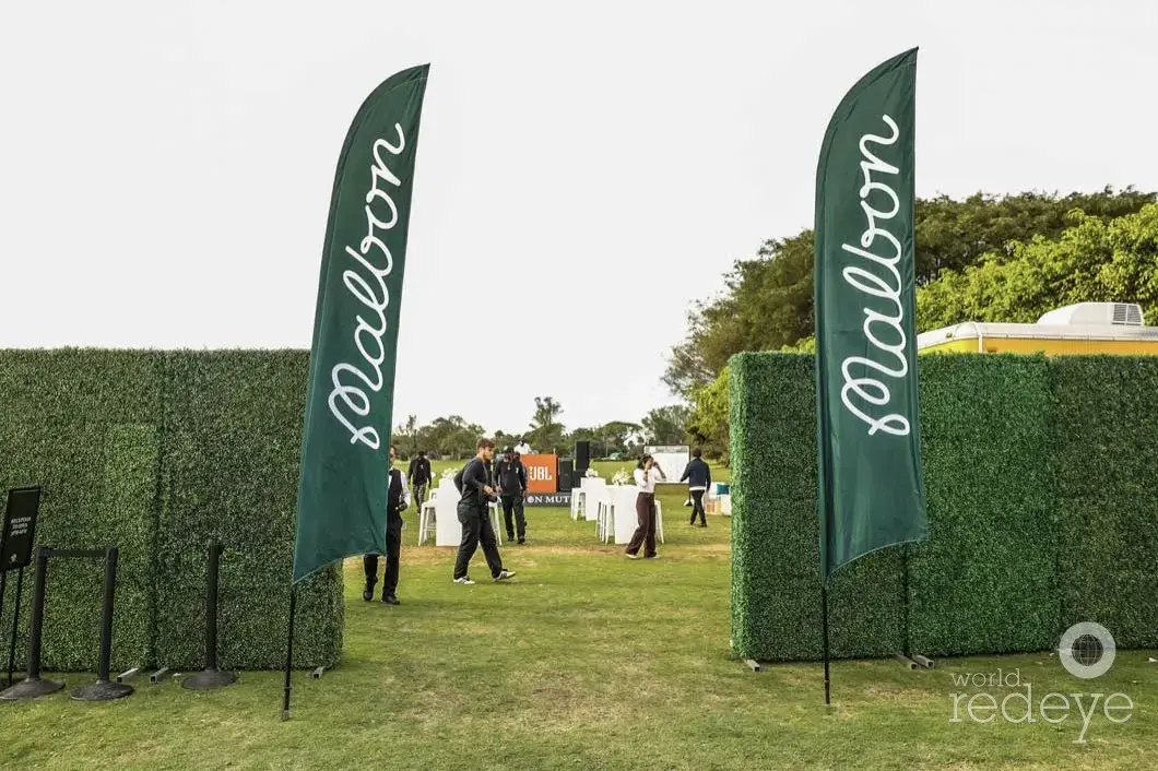 A pair of custom-printed event flags for Malbon Golf at a Golf Tournament